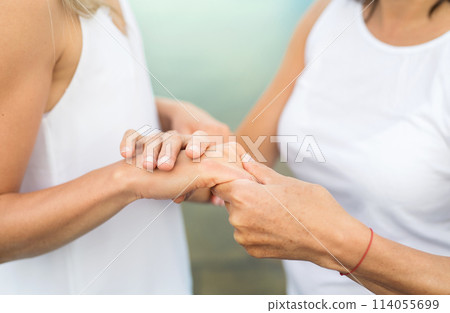 Close up of mother and daughter holding hands. 114055699