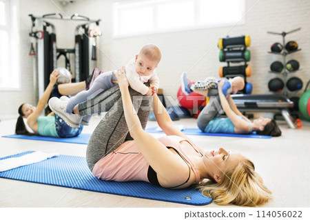 Baby as part of mother's exercise, fitness seasson. Group exercise class, pilates for parents. Moms staying active while boding with babies. 114056022