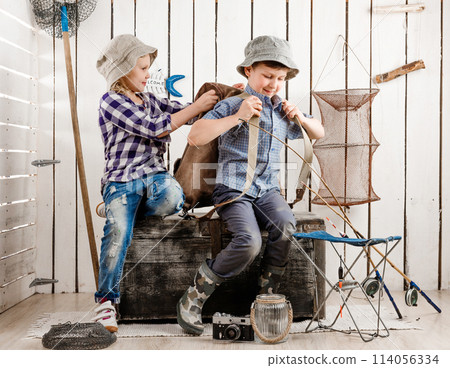 little girl and boy on old big chest putting on backpack little girl and boy on old big chest putting on backpack 114056334