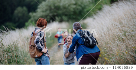 Young students having fun during biology field teaching class, running down the dirt path. Dedicated teachers during outdoor active education teaching about ecosystem, ecology. 114056889
