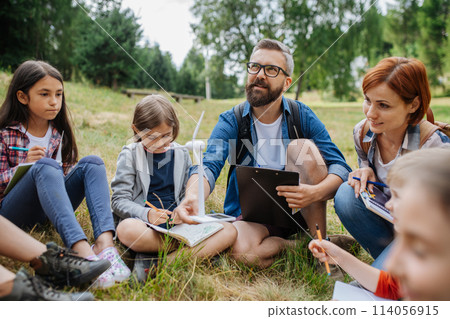 Students learning about renewable wind energy during field teaching class. Outdoor active education helping young student to learn about ecology and sustainability. 114056915