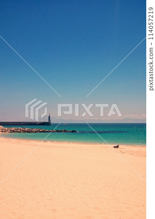 Atlantic ocean and beach with golden sand and blue sky in Tarifa, Spain. Playa de Bolonia on Atlantic coast of Tarifa, Province of Cadiz, Andalucia, southern Spain. Waves on Levante wind on summer day 114057219
