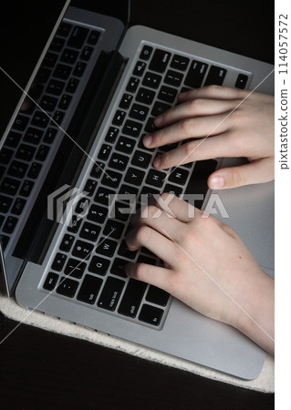 Detailed image of a young person's palms poised above a laptop keyboard, symbolizing proficiency in digital communication and computer usage. 114057572