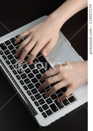 Close-up view of a teen's palms resting on a computer keyboard, highlighting their adeptness in navigating digital devices and applications. 114057574