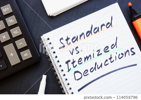 Open notepad and handwritten inscription. Standard vs Itemized deductions. Open notepad and handwritten inscription. Standard vs Itemized deductions. 114058796