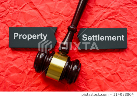 Property settlement concept. Split tablet and gavel on crumpled paper. Property settlement concept. Split tablet and gavel on crumpled paper. 114058804