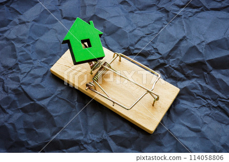 Small house trapped as a symbol of real estate fraud. 114058806