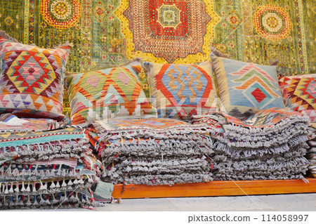 Colourful cushions and carpet on display for sale in a traditional Turkish Bazaar. Colourful cushions and carpet on display for sale in a traditional Turkish Bazaar. 114058997