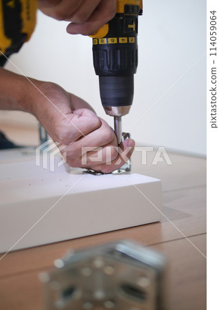 using electric drilling on white wooden board using electric drilling on white wooden board 114059064