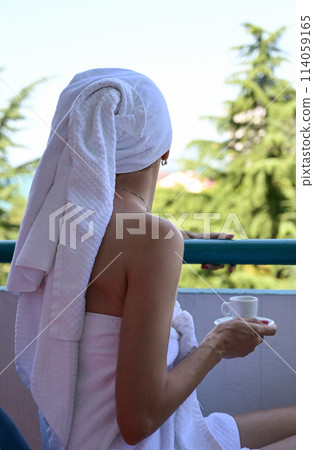 View of the reverse side of a beautiful luxury relaxing woman enjoying a cup of coffee tea on a blue sky sea outdoor background View of the reverse side of a beautiful luxury relaxing woman enjoying a cup of coffee tea on a blue sky sea outdoor background 114059165