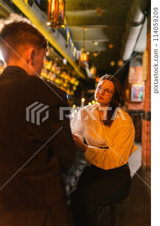 Depressed lady feels apathy for guy at bar counter Depressed lady feels apathy for guy at bar counter 114059209