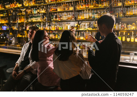 Young guy feels uncomfortable at meeting with friends in bar 114059247