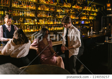 Pretty female ignores man with cocktail at work event in pub 114059257