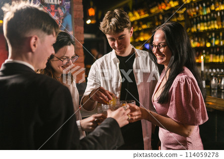 Close friends drink alcoholic cocktails in cozy atmosphere 114059278