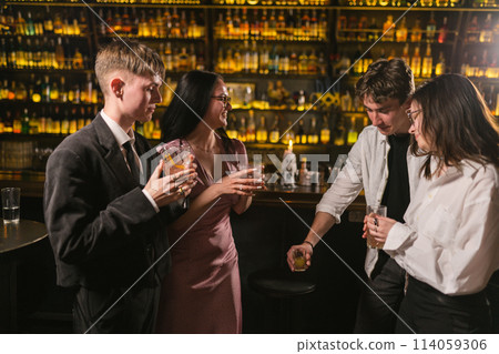 Brunette woman tells funny story to close friends near bar Brunette woman tells funny story to close friends near bar 114059306