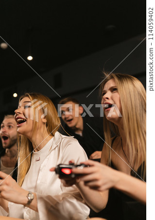 Cheerful young people share excitement during gaming marathon Cheerful young people share excitement during gaming marathon 114059402