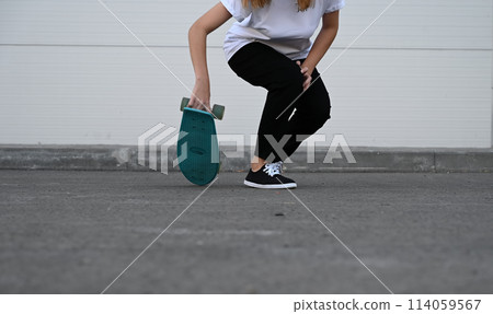 Beautiful and blonde girl practicing long board on the road 114059567