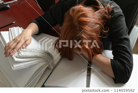 Rear view of female financial manager drawing various charts and schemes on wall in office 114059582