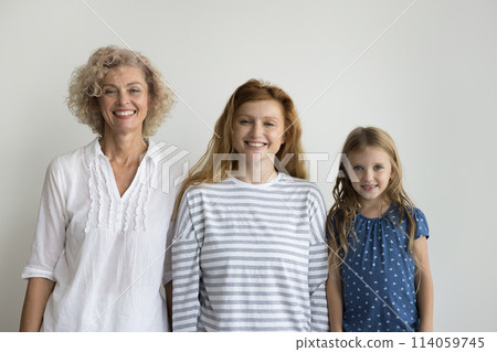 Three smiling beautiful relatives women posing on gray studio background 114059745