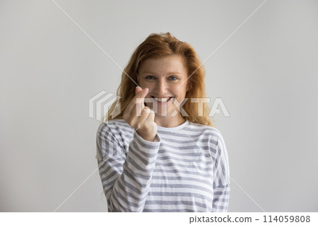 Studio portrait of attractive ginger woman showing cash gesture 114059808
