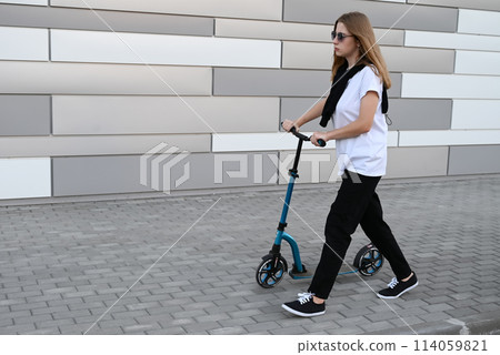 Beautiful and blonde girl practicing long board on the road 114059821