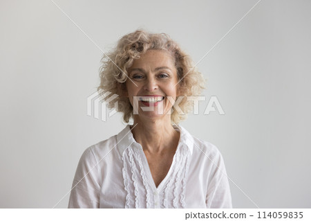 Beautiful blond curly-haired mature woman posing in studio 114059835