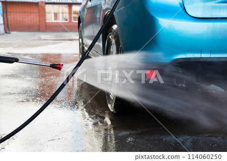 Manual car wash with pressurized water in car wash outside. Summer Car Washing. Cleaning Car Using High Pressure Water. Washing with soap. Close up concept. Manual car wash with pressurized water in car wash outside. Summer Car Washing. Cleaning Car Using High Pressure Water. Washing with soap. Close up concept. 114060250
