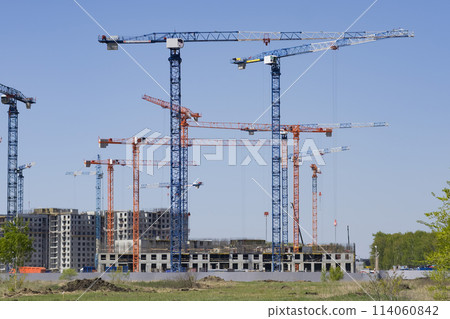 Construction of new residential high-rise buildings. Against the background of a yellow sunset sky. 114060842