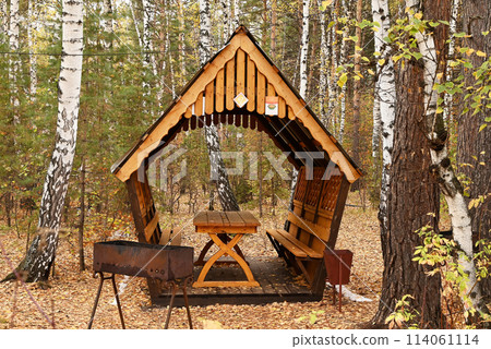 Wooden gazebo in the autumn forest. Barbecue area.The concept of recreation. Wooden gazebo in the autumn forest. Barbecue area.The concept of recreation. 114061114