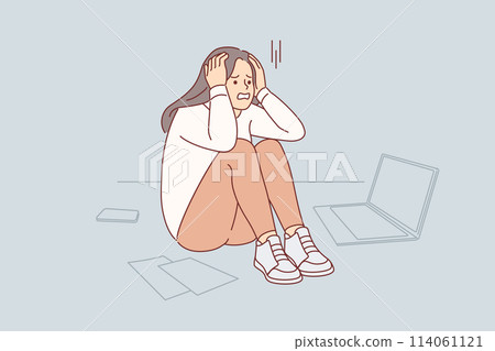Upset cold woman suffering from stress or burnout, sitting on floor near papers and laptop 114061121