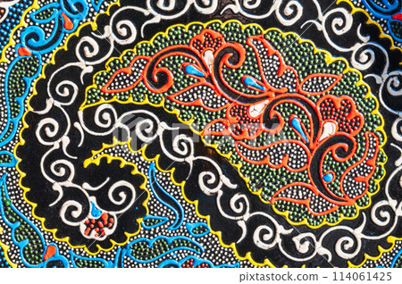 colorful pattern on traditional oriental Uzbek ceramic plates hand-painted in indian style closeup 114061425