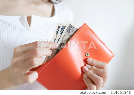 Woman paying money out of her wallet 114061548