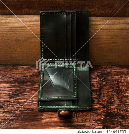 Men's wallet made of black leather on dark stylish wood. Shooting for the catalog Men's wallet made of black leather on dark stylish wood. Shooting for the catalog 114061765