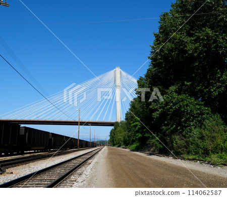 port mann bridge canada over the Fraser River in BC interesting unusual footage of bridge from bottom up green trees railroad Earth on siphon of blue cloudless sky background for advertising text port mann bridge canada over the Fraser River in BC interesting unusual footage of bridge from bottom up green trees railroad Earth on siphon of blue cloudless sky background for advertising text 114062587