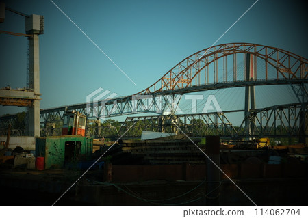Pattullo Bridge over The Fraser River Patullo Bridge, Surrey, British Columbia, Canada. Long exposure of the bridge over water. Sky Train Bridge. bridge in form of pink arch next to other bridges 114062704