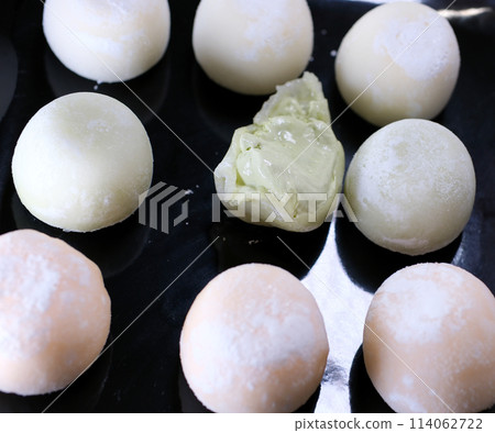mochi ice cream take a bite of dessert and put it back on a black plate with green tea flavor a popular Asian delicacy rice flour mochi ice cream take a bite of dessert and put it back on a black plate with green tea flavor a popular Asian delicacy rice flour 114062722