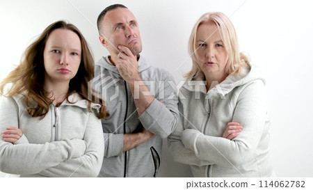 three dissatisfied indignant people a man two women a young teenage girl middle-aged people look evilly into the frame and dance an angry look 114062782