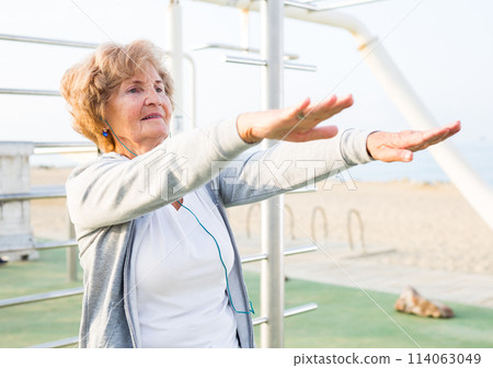 Old woman doing fitness exercises outdoors Old woman doing fitness exercises outdoors 114063049