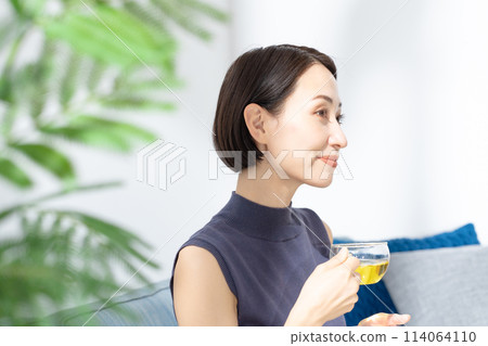 一個女人在一個房間裡喝茶 114064110