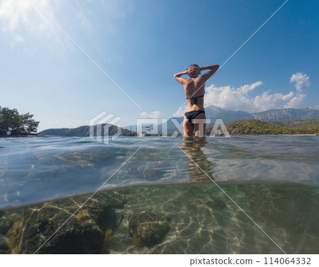 Woman on tropical vacation paradise on sea. Summer sea joy in Turkish seacoast, beaches along Lycian Way, Turkish Riviera. Asian female underwater and turquoise ocean around. 114064332