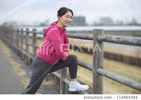 A smiling middle-aged woman wearing sportswear 114064368