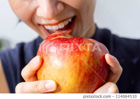 Woman holding a fresh apple Woman holding a fresh apple 114064510