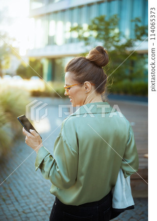 business woman in green blouse and eyeglasses using phone business woman in green blouse and eyeglasses using phone 114065373