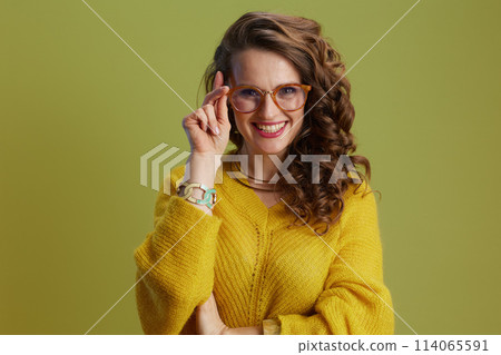 happy fit woman in sweater and glasses isolated on green 114065591
