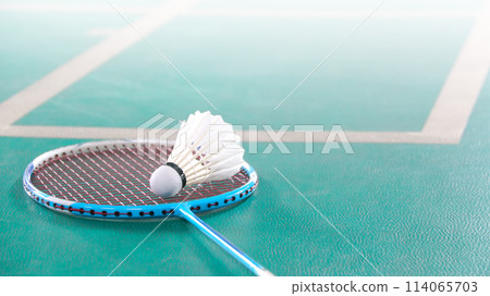 White badminton shuttlecocks and badminton rackets on green floor indoor badminton court White badminton shuttlecocks and badminton rackets on green floor indoor badminton court 114065703