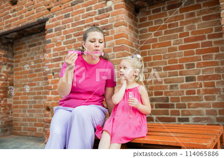 Child girl with cochlear implant with her mother spend time outdoor. Hear impairment and deaf community concept. Deaf and health concept. Disability and inclusion. Copy space 114065886