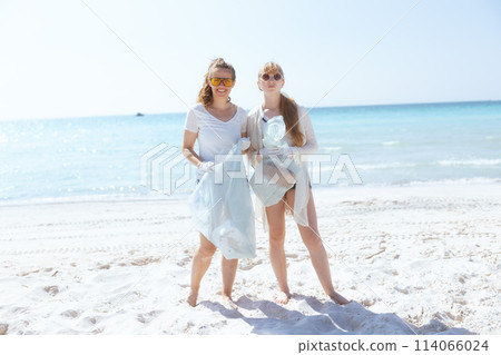 smiling eco activists on seacoast collecting trash 114066024