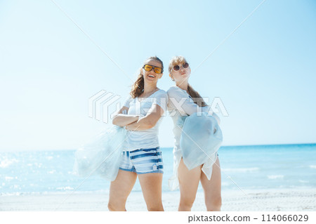 smiling eco activists on beach collecting trash 114066029