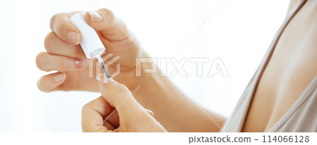 Closeup on young woman applying nail polish 114066128