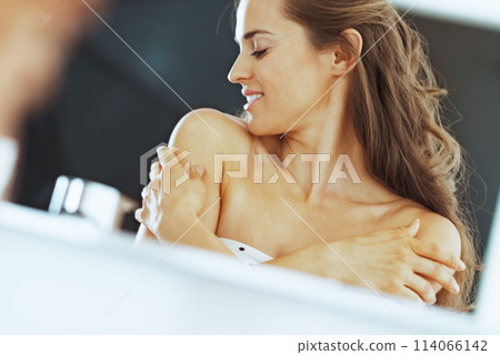 young woman in bathroom happy with her skin conditio 114066142